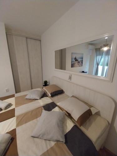 two beds in a room with a mirror at SOBE ŠOTIĆ in Rab