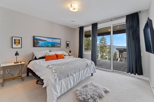 a bedroom with a bed and a large window at Luxury Home with Amazing Lake Okanagan Views in Kelowna
