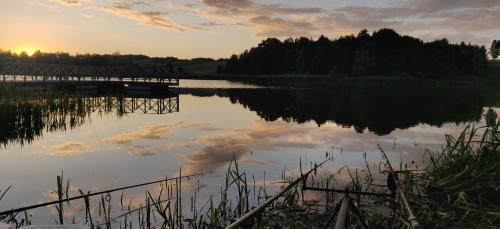 a view of a lake at sunset with clouds in the water at Apartament Turysty Zamczysko in Zamość