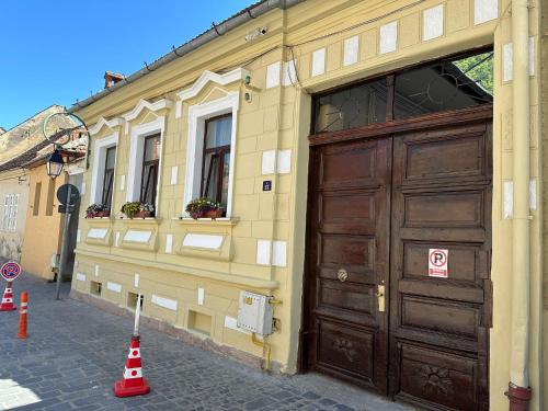 a building with a large wooden door on the side of it at ALBERT RESIDENCE Aparthotel in Braşov