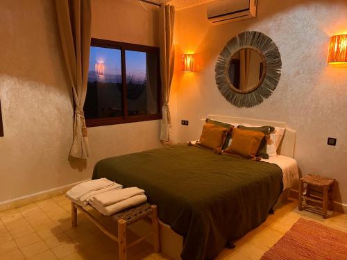 - une chambre avec un lit, un miroir et une fenêtre dans l'établissement Villa Dar Hadjar, à Marrakech