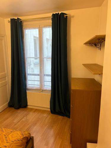 - une chambre dotée d'une fenêtre avec des rideaux noirs dans l'établissement Havre de paix Paris 9, à Paris