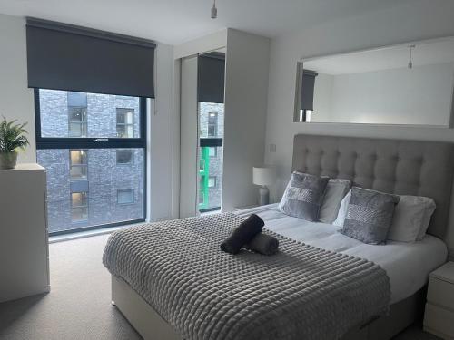 a bedroom with a large bed and two windows at Manchester City Center Apartment in Manchester