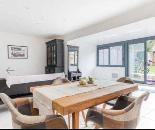 - une salle à manger avec une table, des chaises et un lit dans l'établissement Élégant Appartement Calme et Spacieux avec Jardin, à Choisy-le-Roi