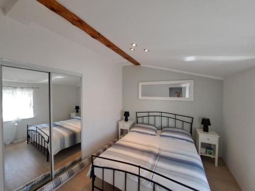 Un dormitorio con dos camas y un espejo. en Apartman Lucia, en Posedarje