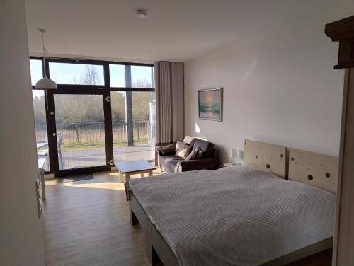 a bedroom with a bed and a living room at Ostseegolf - Ferienappartement in Hohen Wieschendorf