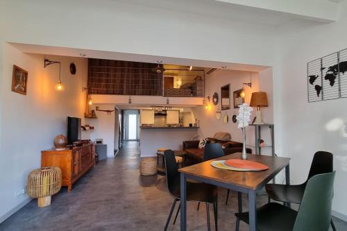 un salon et une salle à manger avec une table et des chaises dans l'établissement Loc Cap Phoebus, atypique, au calme dans la Pinède, au Cap d'Agde