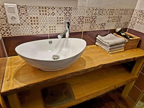 een witte wastafel op een houten aanrecht in de badkamer bij Les Vergers d'Epona "Fremifontaine VOSGES" in Frémifontaine