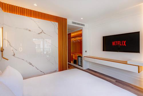 a bedroom with a bed and a tv on a wall at Dulcet Hotel in Antalya