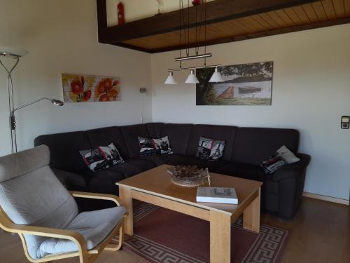 a living room with a black couch and a table at Villa Leni im Schwarzwald in Bad Dürrheim