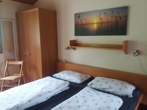 een slaapkamer met 2 bedden en een foto aan de muur bij Villa Leni im Schwarzwald in Bad Dürrheim