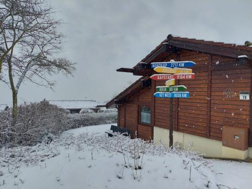 a building with signs on it in the snow at Villa Leni im Schwarzwald in Bad Dürrheim
