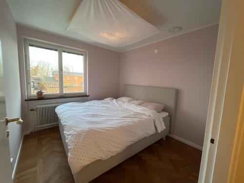 - une chambre avec un lit blanc et une fenêtre dans l'établissement Lidingö, à Lidingö