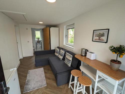 een woonkamer met een bank en een tafel bij En-suite double room with private entrance in Edinburgh