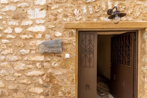 a building with a door and a stone wall at God's View Tower - Pyrgos Towers Complex in Pírgos
