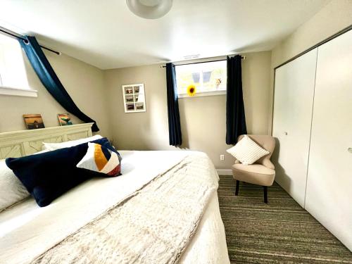 ein Schlafzimmer mit einem Bett, einem Stuhl und einem Fenster in der Unterkunft Yellow Door Suite in Campbell River