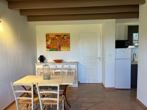 une cuisine avec une table et des chaises et un réfrigérateur blanc dans l'établissement villa 4 personnes avec piscine en camargue, à Gallargues-le-Montueux