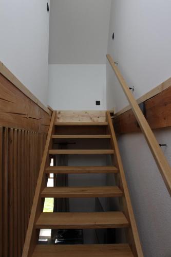 a wooden staircase in a room with a white wall at Apartmán Špejchar Starý Plzenec in Starý Plzenec