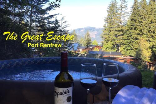 a bottle of wine and two glasses on a table at The Great Escape - Port Renfrew in Port Renfrew