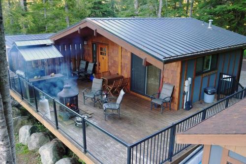 a cabin with a grill on a deck at The Great Escape - Port Renfrew in Port Renfrew