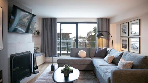 a living room with a couch and a fireplace at Carleton Lodge in Whistler