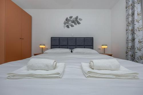 a large white bed with two white towels on it at Villa Fran, Krk in Sveti Vid-Miholjice