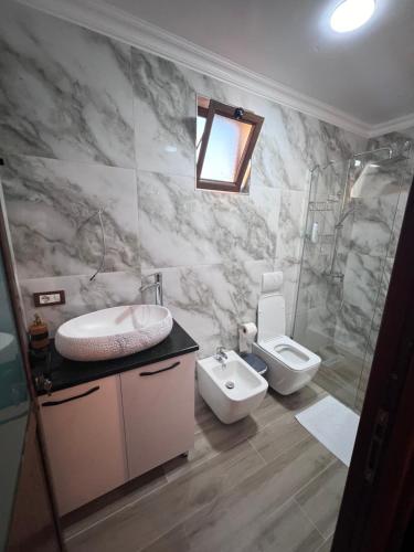 a bathroom with a sink and a toilet at HOTEL MEGNIAR in Lushnjë