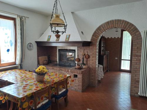 a dining room with a table and a fireplace at Guest House San Francesco Garden in Rapolano Terme