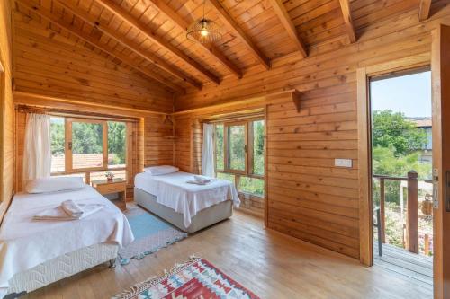 - une chambre avec 2 lits dans une maison en bois dans l'établissement Aylin Ahşap Evler, à Yakaköy
