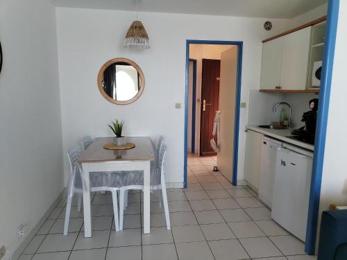 Una cocina con una mesa y sillas en una habitación. en Cap sur le Lac, en Le Barcarès