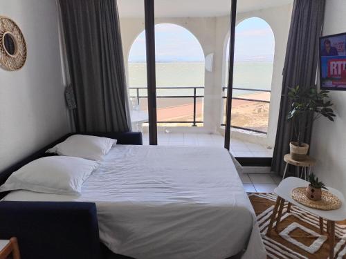 une chambre avec un lit et une vue sur l'océan dans l'établissement Cap sur le Lac, au Barcarès