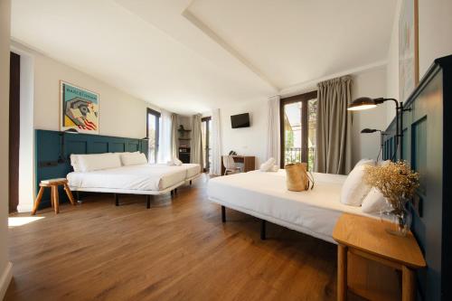 a large room with two beds and a table at Som Nit Port Vell in Barcelona