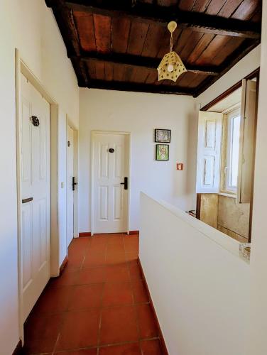 a hallway with white walls and a wooden ceiling at Torre de Santiago - Guest House in Vila Praia de Âncora