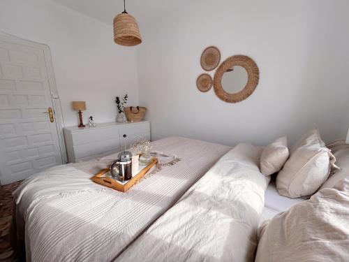 ein weißes Bett mit einem Tablett mit Essen drauf. in der Unterkunft Casa Barman Casco Antiguo Y Vistas Al Mar in Altea