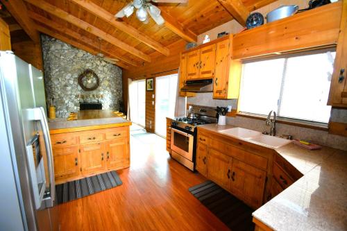 cocina con armarios de madera y horno con fogones en Beautiful Lake Front home with gazebo - Johnson, en Bass Lake