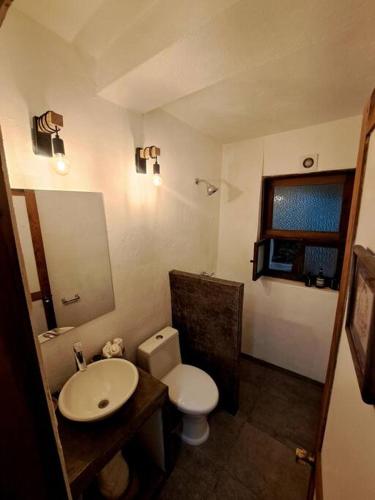 a bathroom with a white toilet and a sink at Casa Nora Malinalco huerto con alberca climatizada in La Ladrillera