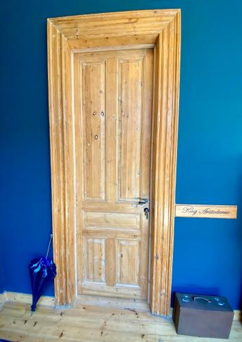 a wooden door in a room with a blue wall at VASILIKON Hotel 1888 the past is present HISTORICAL PRESERVATION MONUMENT in Kalamata