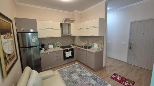 a small kitchen with a couch and a refrigerator at Aurora appartment in Tirana