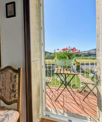 a balcony with a table with a vase of flowers at Torre de Santiago - Guest House in Vila Praia de Âncora