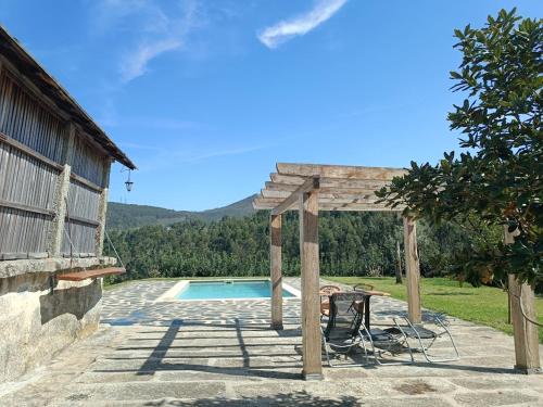 uma pérgola de madeira junto a uma piscina em Abrigo das Andorinhas em Aveiro