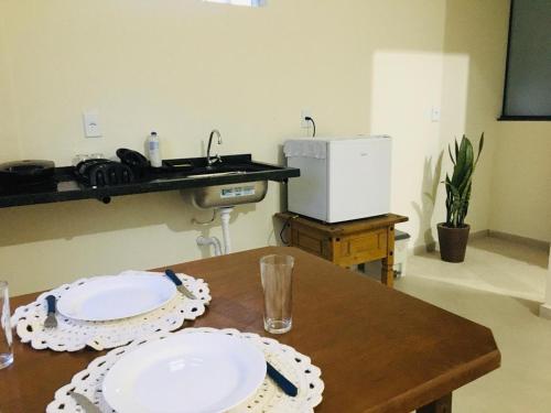 a table with two white plates on top of it at Apartamento Central 3 Centro Cunha in Cunha