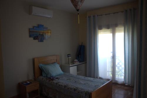 a bedroom with a bed and a large window at Marinazur in Saidia 