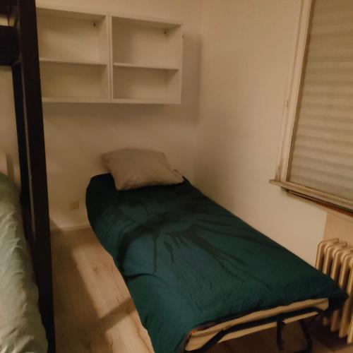 ein kleines Zimmer mit einem grünen Bett. in der Unterkunft 201Hervale in Straßburg