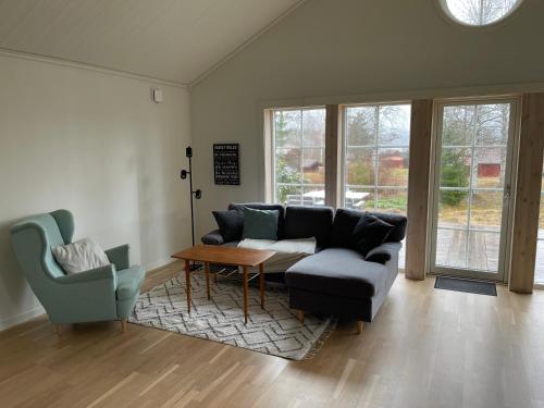 - un salon avec un canapé, une table et des chaises dans l'établissement Stuga, à Leksand