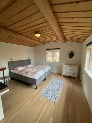 1 dormitorio con cama y techo de madera en Stuga en Leksand