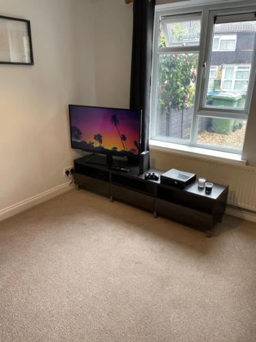 a living room with a flat screen tv on a table at Guest House with garden and 2x parking space in Southampton