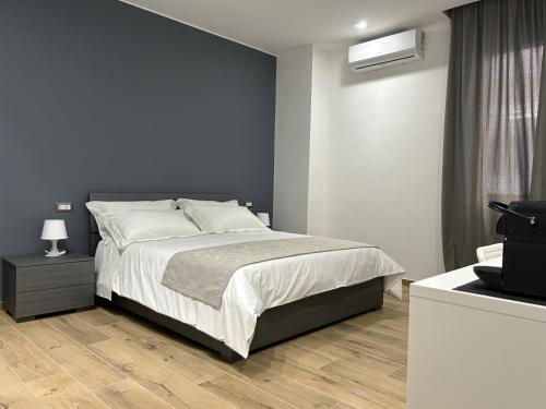 Un dormitorio con una cama con una pared azul. en BB Incentro Trani, en Trani