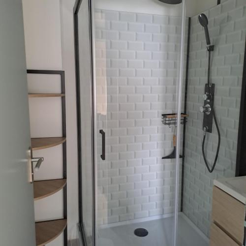 une douche avec une porte vitrée dans une salle de bain dans l'établissement Les bastides de la plage-400 m de la plage, au Grau-du-Roi
