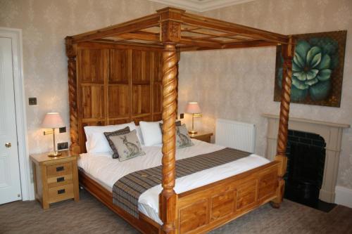 Cama de madera con dosel en un dormitorio con 2 lámparas en The Rectory Lacock - Boutique Bed and Breakfast en Lacock