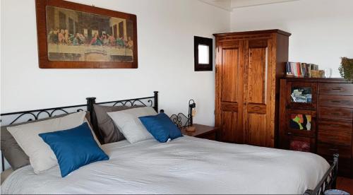 Schlafzimmer mit einem Bett mit blauen und weißen Kissen in der Unterkunft Elvira in Tías